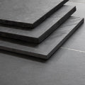 Stacked Brazilian black riven slate hearth slabs showing sawn edge finish