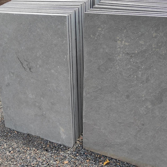 Stacked dove grey limestone hearth slabs ready for crating at our Colchester depot.