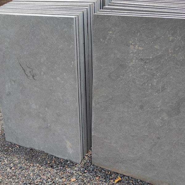 Stacked dove grey limestone hearth slabs ready for crating at our Colchester depot.
