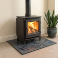 Smooth honed Brazilian black slate hearth plate under a wood burning stove