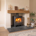 Side perspective of a natural riven black slate hearth floor plate fitted inside a modern fireplace opening.