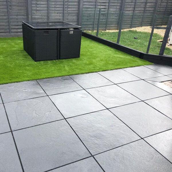 black limestone 600x600 wet with green grass and black wood panels 